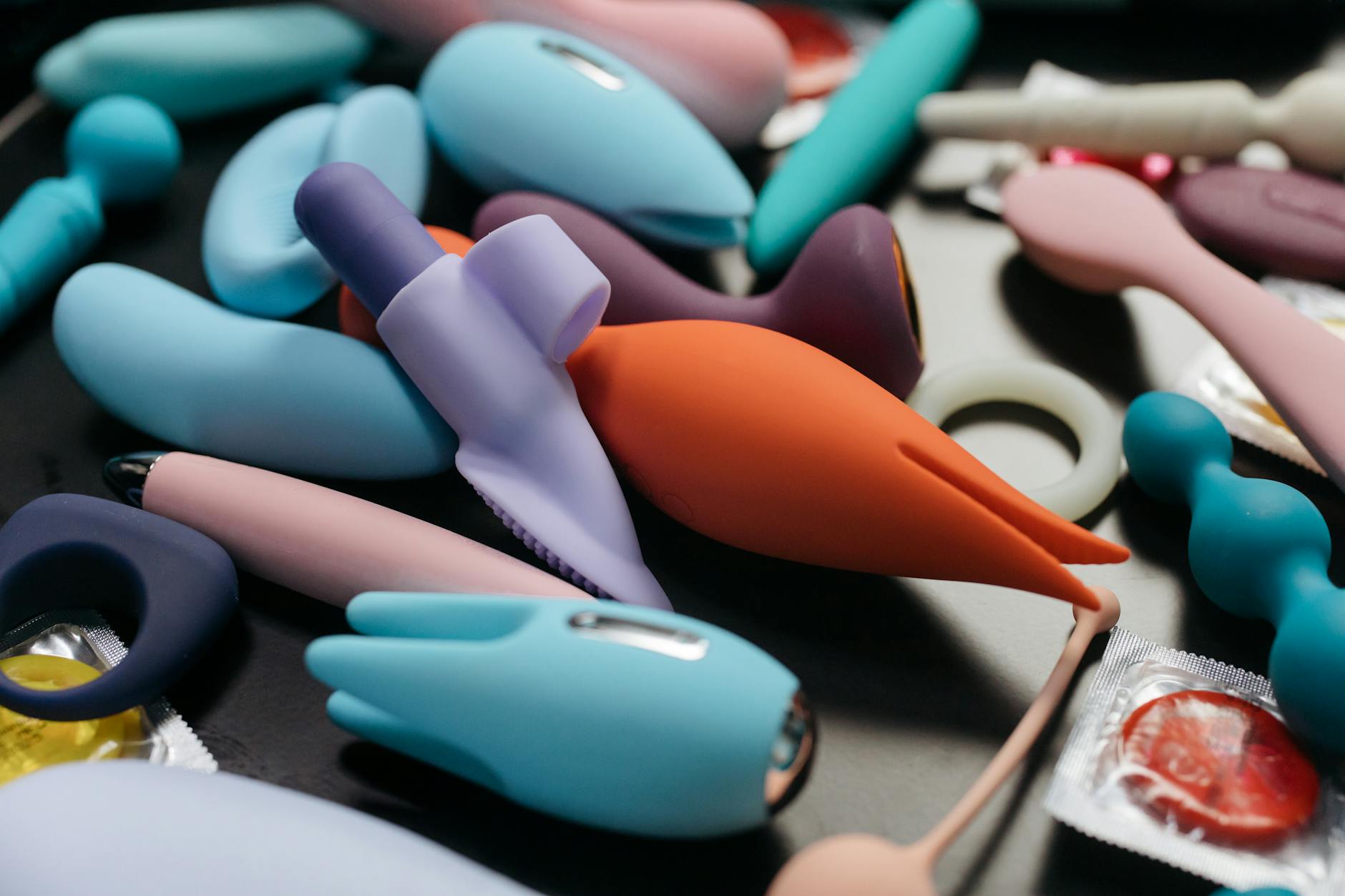 Close-up of vibrant adult toys including vibrators arranged together, representing options for couples navigating mismatched desire.