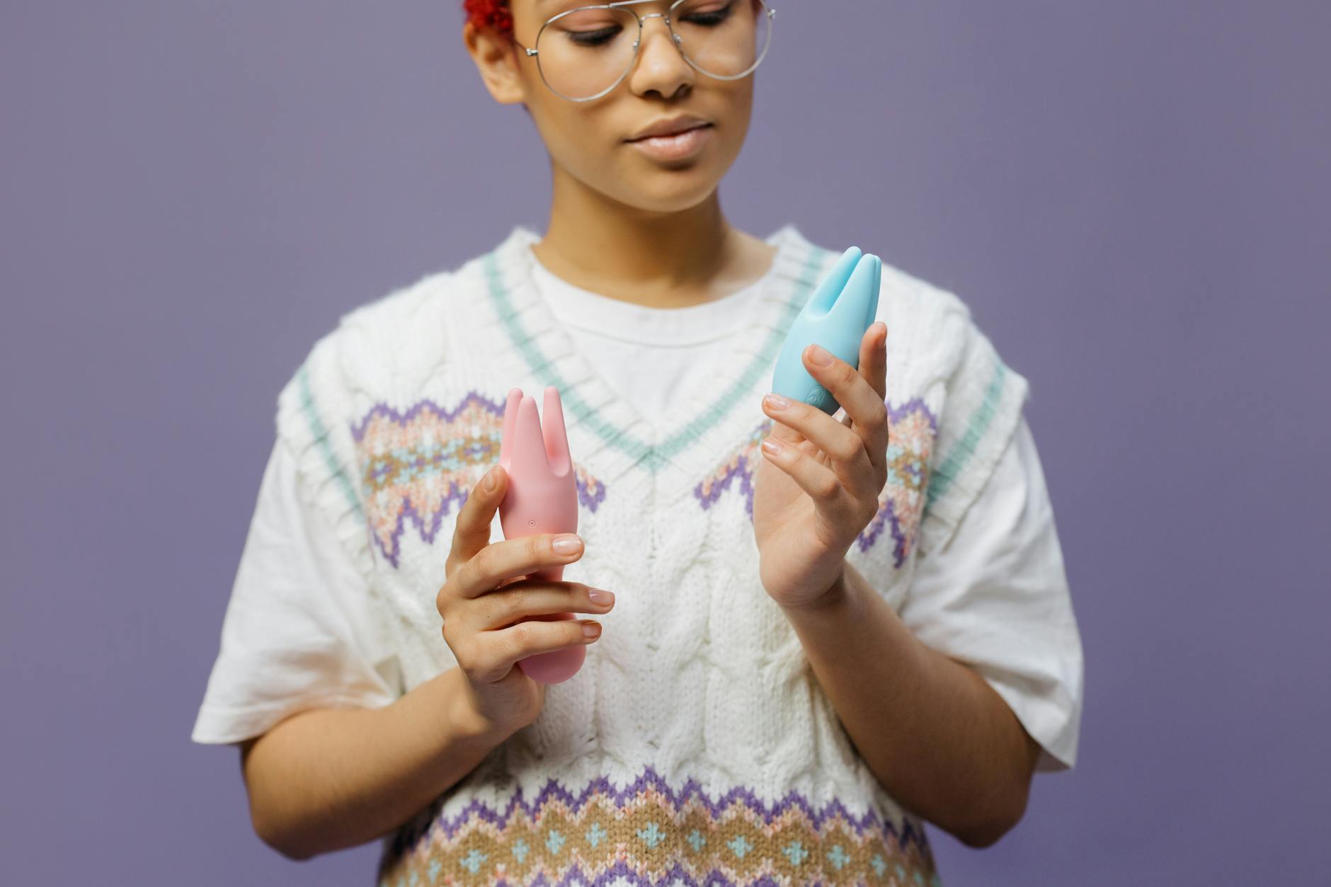 A young couple standing together indoors, holding a blue vibrator, symbolizing modern intimacy.